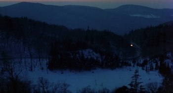 Movie still from “Wolf” (1994), directed by Mike Nichols – A view of a snowy landscape at night with trees; Extreme Wide shot, High angle