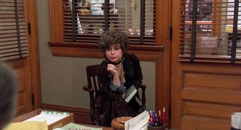 Movie still from “Wolf” (1994), directed by Mike Nichols – A woman sitting at a table in front of a cake; Medium shot, High angle