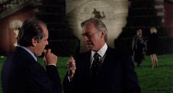 Movie still from “Wolf” (1994), directed by Mike Nichols – Two men in business suits and ties are talking; Close Up shot, Over the shoulder angle