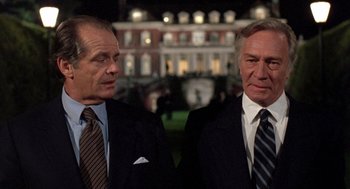 Movie still from “Wolf” (1994), directed by Mike Nichols – Two men in suits standing next to each other; Medium shot, Low angle