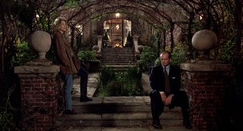 Movie still from “Wolf” (1994), directed by Mike Nichols – A man and a woman sitting on steps in front of a house; Wide shot, Low angle
