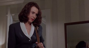 Movie still from “Wolf” (1994), directed by Mike Nichols – A woman holding a cane in a room with a mirror; Medium shot, Low angle