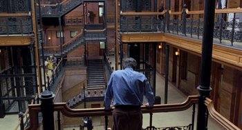 Movie still from “Wolf” (1994), directed by Mike Nichols – A man standing on the stairs of an old building; Extreme Wide shot, High angle