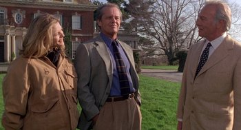Movie still from “Wolf” (1994), directed by Mike Nichols – A man and two women standing next to each other in front of a house; Medium shot, Low angle