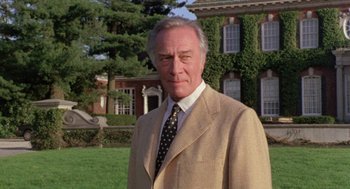 Movie still from “Wolf” (1994), directed by Mike Nichols – An older man wearing a suit and tie in front of a house; Close Up shot, Low angle