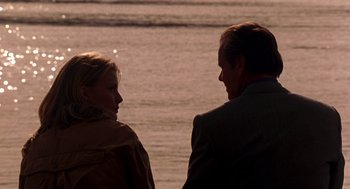 Movie still from “Wolf” (1994), directed by Mike Nichols – A man and a woman sitting next to a body of water; Close Up shot, Over the shoulder angle