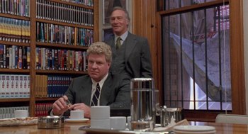 Movie still from “Wolf” (1994), directed by Mike Nichols – Two men sitting at a table in a room; Medium shot, Low angle