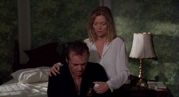 Movie still from “Wolf” (1994), directed by Mike Nichols – A man and a woman are sitting on a bed together; Medium shot, Low angle