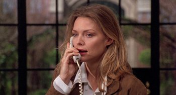 Movie still from “Wolf” (1994), directed by Mike Nichols – A woman talking on a phone while wearing a brown jacket; Close Up shot, High angle