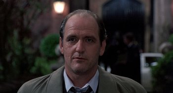 Movie still from “Wolf” (1994), directed by Mike Nichols – A person wearing a suit and tie; Close Up shot, Over the shoulder angle