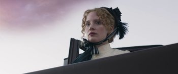 Movie still from “Woman Walks Ahead” (2017), directed by Susanna White – A woman with a feather in her hair; Close Up shot, Low angle
