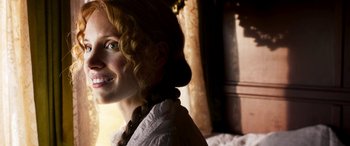 Movie still from “Woman Walks Ahead” (2017), directed by Susanna White – A person with curly hair; Close Up shot, Over the shoulder angle