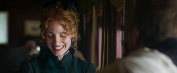 Movie still from “Woman Walks Ahead” (2017), directed by Susanna White – A young woman smiling with her eyes closed; Close Up shot, Over the shoulder angle