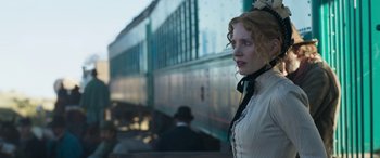 Movie still from “Woman Walks Ahead” (2017), directed by Susanna White – A woman standing in front of a train on a train platform; Medium shot, Low angle