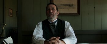 Movie still from “Woman Walks Ahead” (2017), directed by Susanna White – An older man wearing a vest and a tie; Close Up shot, Low angle