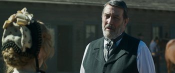 Movie still from “Woman Walks Ahead” (2017), directed by Susanna White – An older man wearing a vest and a tie; Close Up shot, Over the shoulder angle