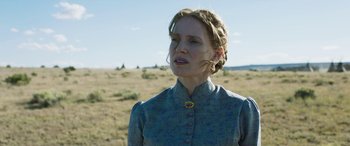 Movie still from “Woman Walks Ahead” (2017), directed by Susanna White – A woman standing in the middle of an open field; Close Up shot, Low angle