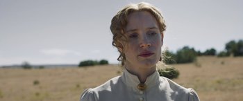 Movie still from “Woman Walks Ahead” (2017), directed by Susanna White – A woman in a white dress standing in a field; Close Up shot, Low angle