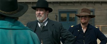 Movie still from “Woman Walks Ahead” (2017), directed by Susanna White – An older man wearing a suit and a hat; Medium shot, Over the shoulder angle