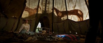 Movie still from “Woman Walks Ahead” (2017), directed by Susanna White – An image of an animal inside a tent in the wild; Wide shot, Low angle