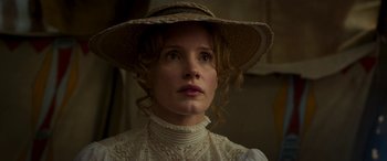 Movie still from “Woman Walks Ahead” (2017), directed by Susanna White – A woman wearing a straw hat and a white dress; Close Up shot, Low angle