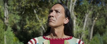 Movie still from “Woman Walks Ahead” (2017), directed by Susanna White – A man in native american clothing looking upward; Close Up shot, Low angle