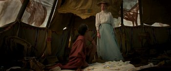 Movie still from “Woman Walks Ahead” (2017), directed by Susanna White – A woman standing next to a man sitting on the ground; Medium shot, Over the shoulder angle