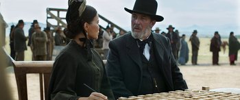 Movie still from “Woman Walks Ahead” (2017), directed by Susanna White – A man and a woman sitting at a table; Medium shot, Over the shoulder angle