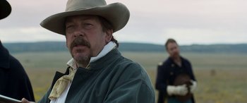 Movie still from “Woman Walks Ahead” (2017), directed by Susanna White – A man in a cowboy hat and a man in a cowboy outfit; Close Up shot, Over the shoulder angle