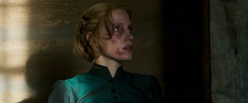 Movie still from “Woman Walks Ahead” (2017), directed by Susanna White – A woman with red hair and a green shirt looking to her left; Close Up shot, Over the shoulder angle