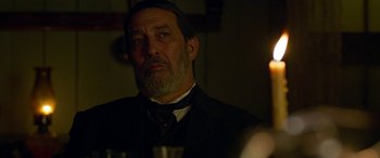 Movie still from “Woman Walks Ahead” (2017), directed by Susanna White – An older man in a suit and a tie; Close Up shot, Over the shoulder angle