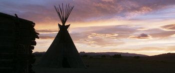 Movie still from “Woman Walks Ahead” (2017), directed by Susanna White – A teepee in the middle of a field at sunset; Extreme Wide shot, Low angle