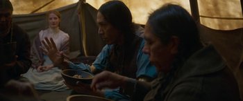 Movie still from “Woman Walks Ahead” (2017), directed by Susanna White – Two native american men sitting down eating food; Medium shot, Over the shoulder angle