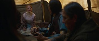 Movie still from “Woman Walks Ahead” (2017), directed by Susanna White – A group of people sitting around a table with food; Medium shot, Over the shoulder angle