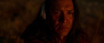 Movie still from “Woman Walks Ahead” (2017), directed by Susanna White – A person with a feather in their hair; Close Up shot, Over the shoulder angle