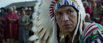 Movie still from “Woman Walks Ahead” (2017), directed by Susanna White – A person wearing a headdress; Close Up shot, Over the shoulder angle