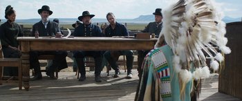 Movie still from “Woman Walks Ahead” (2017), directed by Susanna White – A group of men sitting around a table; Medium shot, Over the shoulder angle