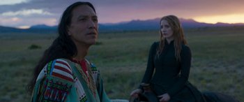 Movie still from “Woman Walks Ahead” (2017), directed by Susanna White – A man and a woman standing next to each other in a field; Medium shot, Over the shoulder angle