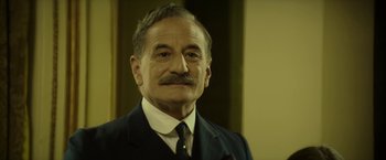 Movie still from “Woman in Gold” (2015), directed by Simon Curtis – An older man with a mustache wearing a suit and tie; Close Up shot, Low angle