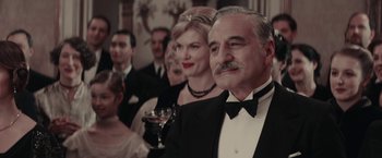 Movie still from “Woman in Gold” (2015), directed by Simon Curtis – A group of people in formal wear standing next to each other; Medium shot, Low angle