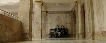 Movie still from “Woman in Gold” (2015), directed by Simon Curtis – A man and a woman sitting on a wooden bench; Wide shot, High angle