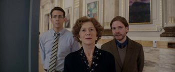 Movie still from “Woman in Gold” (2015), directed by Simon Curtis – A woman and two men standing next to each other in a room; Medium shot, Low angle