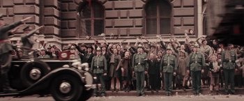 Movie still from “Woman in Gold” (2015), directed by Simon Curtis – A group of people standing next to each other on a street; Wide shot, High angle