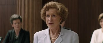 Movie still from “Woman in Gold” (2015), directed by Simon Curtis – An older woman wearing a white jacket and pearls; Close Up shot, Over the shoulder angle