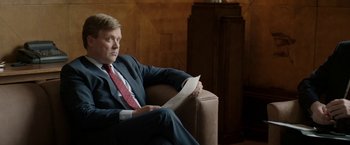 Movie still from “Woman in Gold” (2015), directed by Simon Curtis – A man sitting in a chair holding a piece of paper; Medium shot, Over the shoulder angle