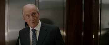 Movie still from “Woman in Gold” (2015), directed by Simon Curtis – An older man wearing a suit and tie in an elevator; Close Up shot, Over the shoulder angle