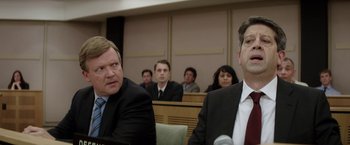 Movie still from “Woman in Gold” (2015), directed by Simon Curtis – A group of people in a room with microphones; Medium shot, Over the shoulder angle