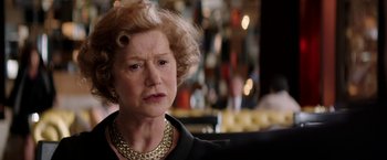 Movie still from “Woman in Gold” (2015), directed by Simon Curtis – An older woman wearing a gold necklace and a black jacket; Close Up shot, Over the shoulder angle