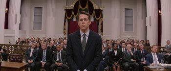 Movie still from “Woman in Gold” (2015), directed by Simon Curtis – A man in a suit and tie in front of an audience; Medium shot, Low angle