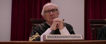 Movie still from “Woman in Gold” (2015), directed by Simon Curtis – An older man sitting at a judge's desk; Close Up shot, Low angle